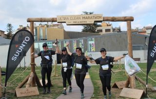 Participants de l'Ultra Clean Marathon creuant la meta amb bosses de residus recollits, demostrant el compromís amb l'esport i el medi ambient. Una iniciativa ecològica que combina running i neteja d'espais naturals.